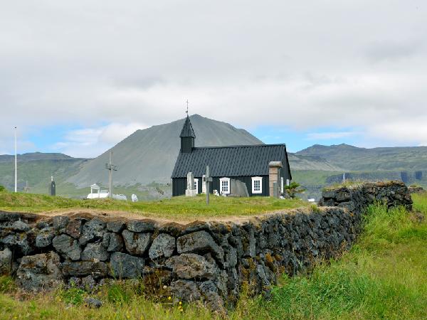 Die schwarze Holzkirche von Budir mit Blick auf den Gletschervulkan Snaefellsjökull...